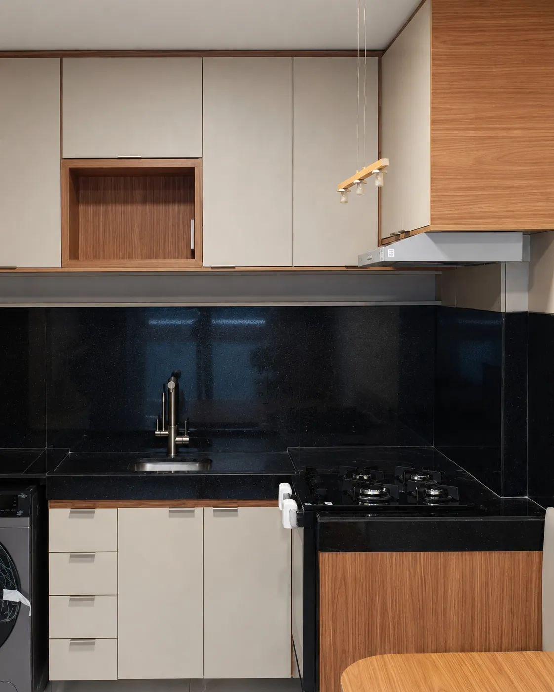 Detalhe do encontro entre o freijó natural e a laca off-white nos armários superiores da cozinha